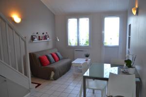 ein Wohnzimmer mit einem Sofa und einem Tisch in der Unterkunft Au Pas Du Chateau in Jonzac