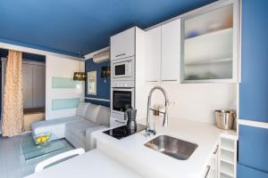 a kitchen with white cabinets and a blue ceiling at Luxury Torremolinos in Torremolinos