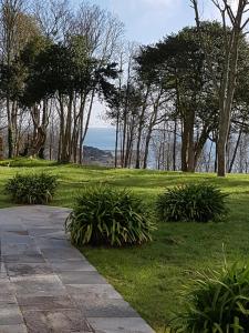 una pasarela en un parque con árboles y césped en Manoir de Kergrec'h en Plougrescant