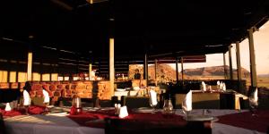 un ristorante con tavoli e sedie con montagne sullo sfondo di Soft Adventure Camp a Solitaire