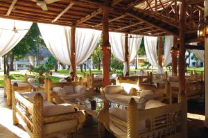 a room with couches and chairs under a pavilion at Sandies Tropical Village in Malindi