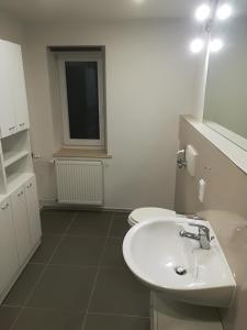 a white bathroom with a sink and a window at Ferienhaus Kurzbach in Velden