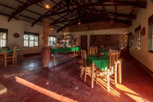 a restaurant with green tables and chairs in a room at Gorilla Valley Lodge in Bwindi Impenetrable Park