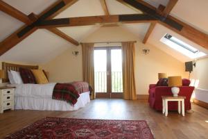 een slaapkamer met een bed en een rode bank bij The Byre in Keswick