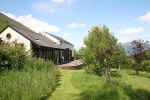 Blick auf ein Haus mit einem Rasenplatz in der Unterkunft The Byre in Keswick