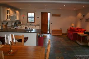 a kitchen and living room with a red couch at The Byre in Keswick