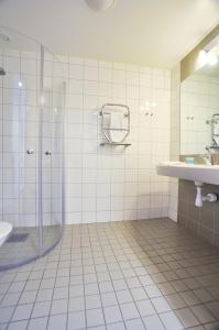 a bathroom with a shower, sink, and mirror at Sky Hotel Apartments, Stockholm in Stockholm