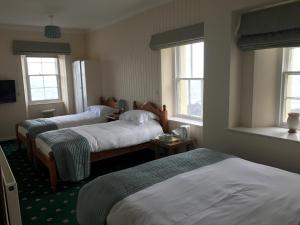 a hotel room with two beds and two windows at Hartland Quay Hotel in Hartland