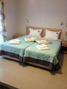 1 dormitorio con 1 cama con 2 toallas en TETYK Keramoti Hotel Apartments, en Keramotí