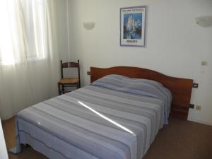 a bedroom with a bed and a chair in it at Le Barry in Villefranche-dʼAlbigeois