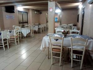 a dining room with white tables and chairs at Hôtel Saint Thomas in Lomé