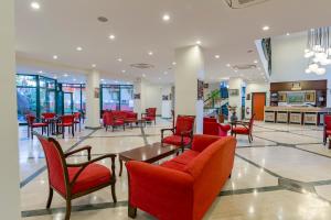 a lobby with red chairs and tables in a building at Hotel Sumela Garden - All Inclusive in Beldibi