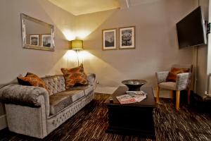 a living room with a couch and a table at The Saracens Head Hotel in Great Dunmow