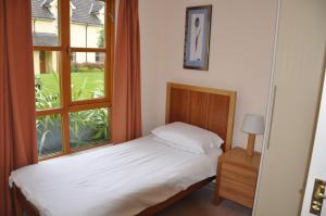 1 dormitorio con cama y ventana en Heyward Mews Holiday Homes No 2, en Swords