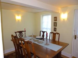 a dining room with a wooden table and chairs at Rock View in Froggatt