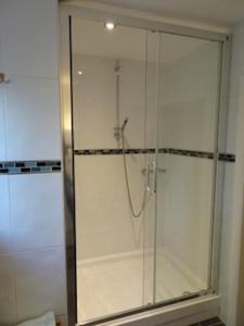 a shower with a glass door in a bathroom at Rock View in Froggatt