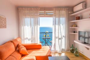 sala de estar con sofá y ventana grande en Piso primera línea de playa, en Málaga