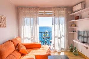 a living room with a couch and a large window at Piso primera línea de playa in Málaga