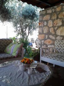 patio con mesa, 2 sillas y pared de piedra en Akay Hotel, en Patara
