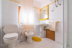 a white bathroom with a toilet and a sink at AffittaSardegna-Casa Lentischio in Stintino +22 photos