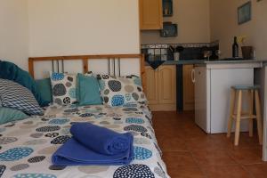 カレタ・デル・セボにあるCasita del Rio 2のキッチンに青い枕が付いたベッド