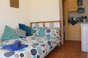 Una cama con sábanas y almohadas azules y blancas. en Casita del Rio 2 en Caleta de Sebo