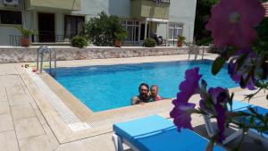two people are sitting in a swimming pool at Akay Hotel in Patara
