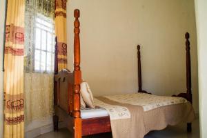 a bedroom with a four poster bed and a window at Marphie Hotel Rukungiri in Rukungiri