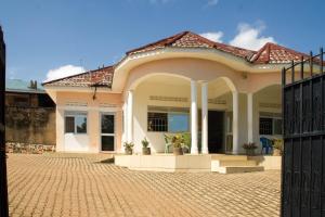 Marphie Hotel Rukungiri في Rukungiri: منزل أمامه بوابة