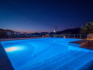 a large blue swimming pool at night at Palataki in Kardamyli