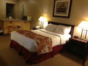 a hotel room with a large bed and two lamps at Petawawa River Inn & Suites in Petawawa