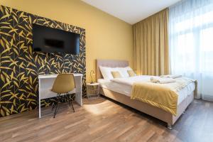 a bedroom with a bed and a tv on a wall at MyApartment in the city center in České Budějovice