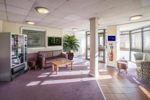 a waiting room with a couch and a table at Redwings Lodge Solihull in Solihull