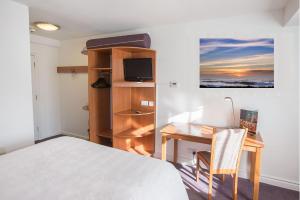 um quarto com uma cama, uma secretária, uma cama, uma secretária e uma cadeira. em Redwings Lodge Solihull em Solihull