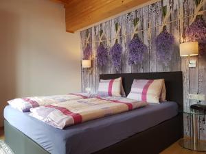 um quarto com uma cama com flores roxas na parede em Hotel Gletschermühle em Flattach