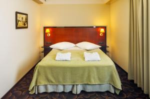 a bedroom with a large bed with two white pillows at Meresuu Spa & Hotel in Narva-Jõesuu