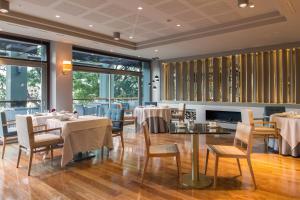 فندق ميرامار برشلونة جي إل في برشلونة: غرفة طعام مع طاولات وكراسي ونوافذ