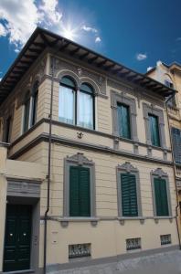 a building with green shutters on the side of it at Palazzo Cini Luxury Rooms in Pisa in Pisa