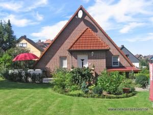 a house with a triangular roof on a yard at DerOstseegast in Heiligenhafen