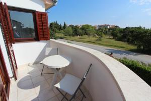 un piccolo tavolo bianco e sedie su un balcone di Rooms and Apartment Luana a Rovigno (Rovinj)