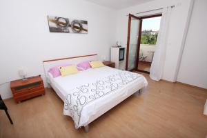 Un dormitorio con una gran cama blanca y una ventana en Rooms and Apartment Luana, en Rovinj