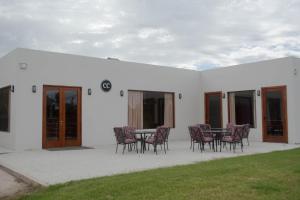 un patio con sillas y una mesa en un edificio blanco en Colón Center in 