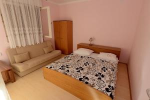 a small bedroom with a bed and a couch at Apartment Kod Stipe in Vrsi