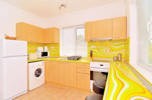 a kitchen with yellow and white stripes on the wall at Villa Knox in Bryastovets