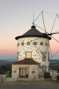 a building with a windmill on top of it at The Moinho House in Laundos