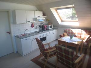 una pequeña cocina con mesa y una cocina con ventana en Haus Wiesengrund, en Werdum