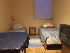 a room with two beds and a flat screen tv at Westwind puhkemaja in Kunda