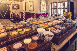 una línea de buffet con muchos tipos diferentes de comida en Hotel Florian Palace en Jindrichuv Hradec