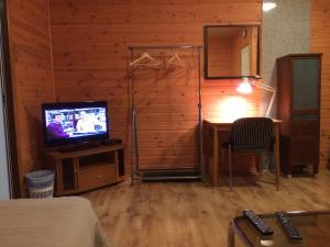 Habitación con TV y escritorio con silla. en Westwind puhkemaja en Kunda