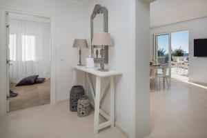 Apartments Coral في بريموستين: غرفة بيضاء مع طاولة بيضاء مع مرآة